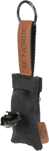 Grauer Stoffspender mit schwarzem Plastikbeutel, brauner Lederlasche mit "BE NORDIC", Metallring oben.