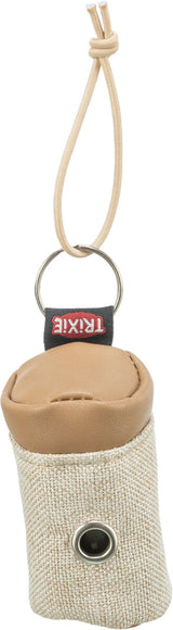 Beutel aus beigem Stoff und braunem Leder mit Aufhänger und Metallring, Emblem mit "TRIXIE" sichtbar.