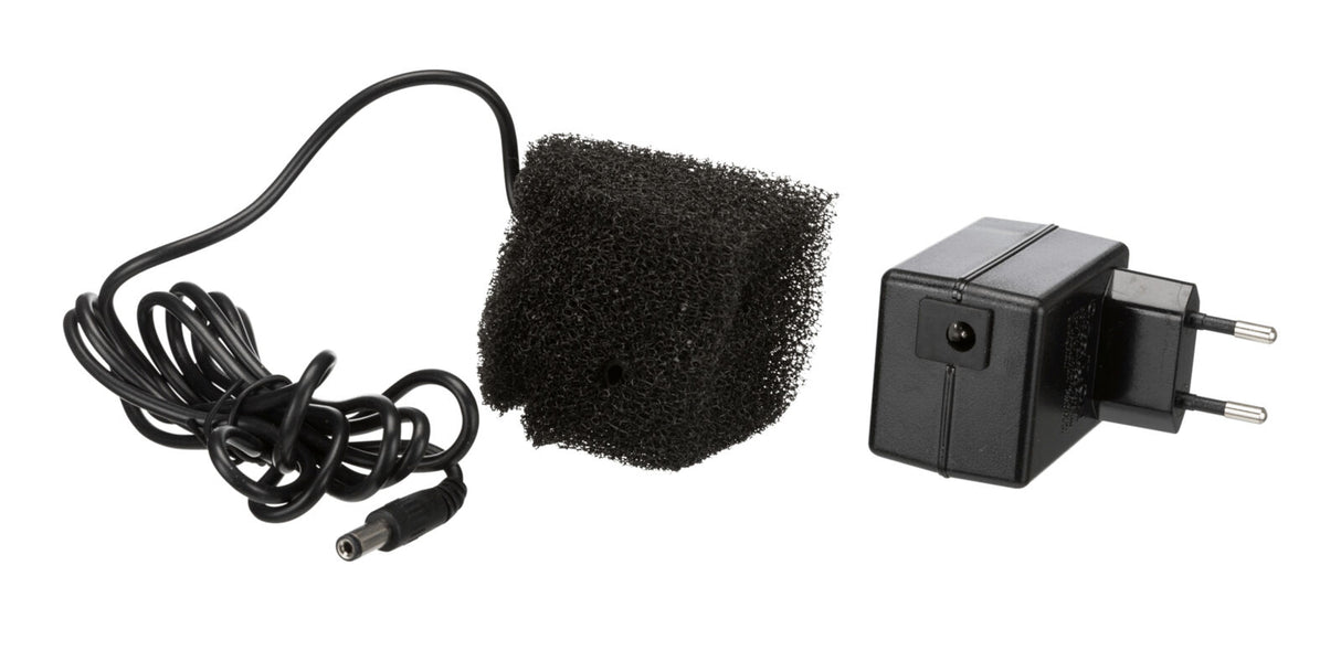 Schwarzes Netzteil mit EU-Stecker, schwarzem Kabel und einem quadratischen, schwarzen Schaumstoffstück.