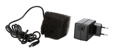 Schwarzes Netzteil mit EU-Stecker, schwarzem Kabel und einem quadratischen, schwarzen Schaumstoffstück.