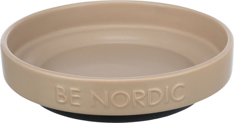 Runder, beigefarbener Napf mit erhabener Schrift "BE NORDIC" am Rand, auf dunklem Unterteil.