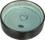 Runde Schale mit schwarzem Rand und hellblauem Innenbereich samt Herz- und Pfotenmotiv sowie "Trixie"-Logo.