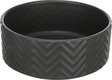 Runde, schwarze Schale mit Zickzack-Muster auf der Außenseite.