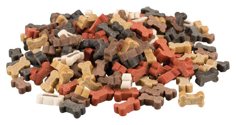 Ein Stapel bunter, knochenförmiger Hundekekse in Rot, Braun, Schwarz, Weiß und Gelb auf weißem Hintergrund.