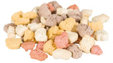 Bunte Tierfutter-Stücke in Weiß, Gelb, Braun und Rosa auf einem Haufen vor weißem Hintergrund.