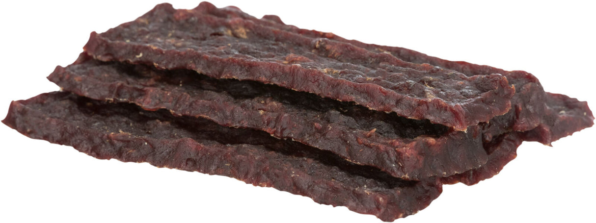 Dunkle, flache Streifen aus getrocknetem Fleisch mit ungleichmäßiger Oberfläche, übereinander gestapelt.