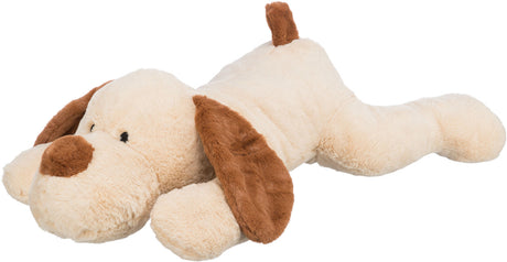 Ein weiches, beiges Kuscheltier in Form eines Hundes mit braunen Ohren und Schwanz liegt ausgestreckt.