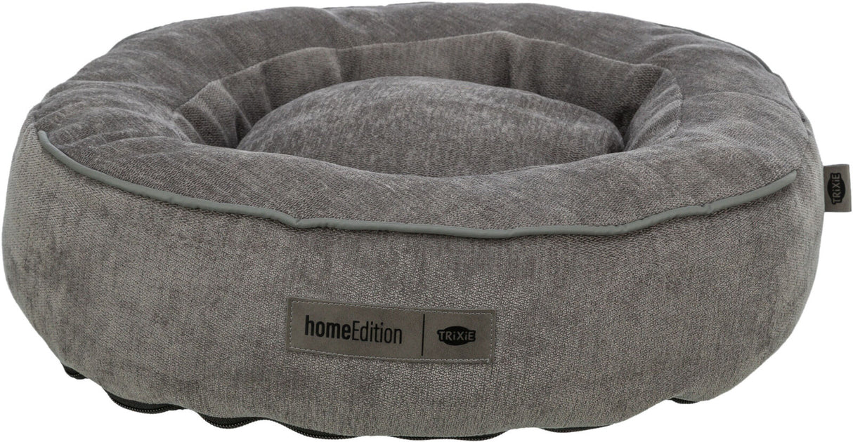 Graues, rundes Hundebett mit erhabenen Rändern, weichem Stoff und einem Etikett mit der Aufschrift "homeEdition Trixie".