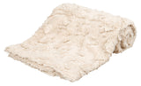 Weiche, cremefarbene Decke aus flauschigem Material, zusammengelegt in einem leicht gerollten Stapel.