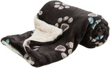 Schwarze Decke mit beigefarbenem, flauschigem Innenfutter und hellen Pfotenabdruckmustern.