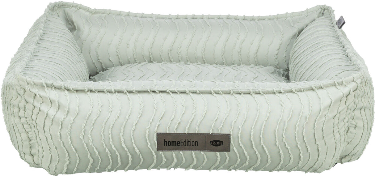 Rechteckiges, pastellgrünes Haustierbett mit wellenartiger Struktur und einem Label "homeEdition Trixie".