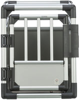 Silberne Hundetransportbox mit schwarzen Ecken und einem Gitter aus vertikalen Stäben, die das Logo "TRIXIE" zeigt.