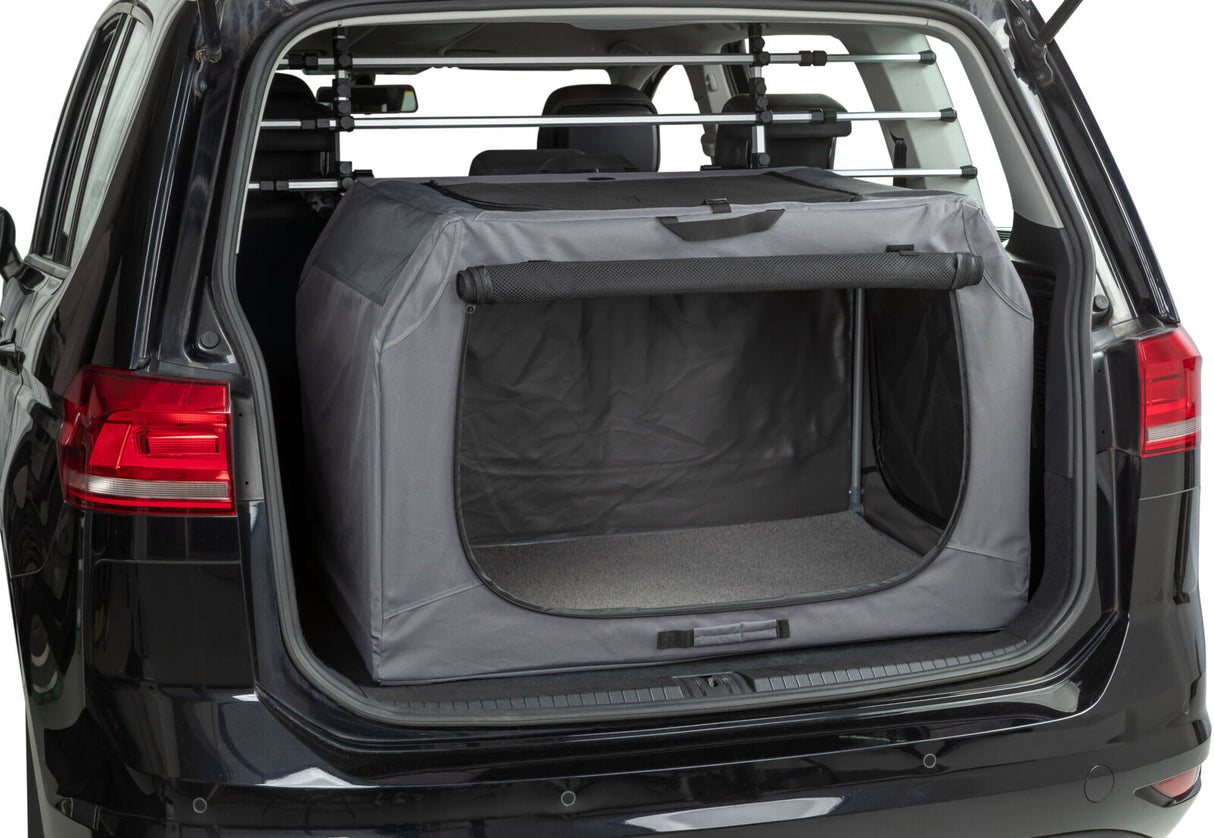 Grau-schwarze Transportbox im Kofferraum eines Autos mit geöffnetem Heck.