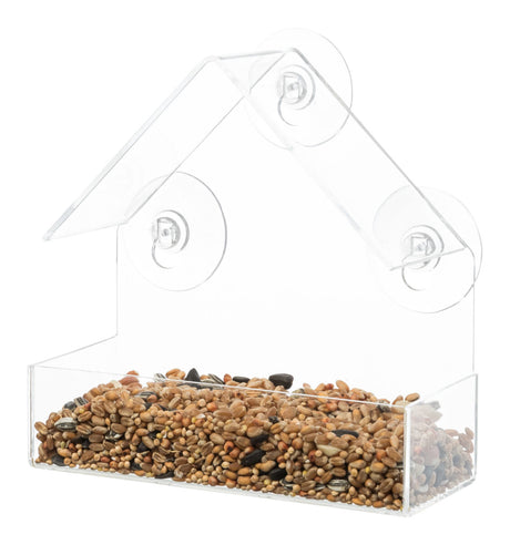 Durchsichtiger Vogelfutterspender aus Kunststoff in Hausform mit Saugnäpfen, gefüllt mit gemischten Körnern.