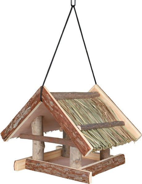 Vogelfutterhaus aus Holz mit Stroh bedecktem Satteldach, hängend an einer schwarzen Kordel befestigt.