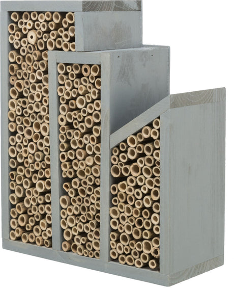 Holzkasten in Grautönen mit vielen kleinen, runden Röhren unterschiedlicher Größe, ordnen sich vertikal an.