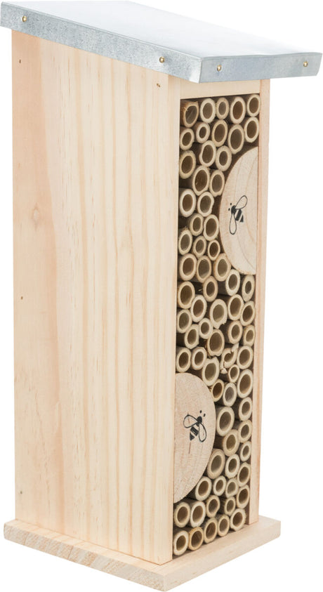 Holzhaus mit Metallspitzdach, gefüllt mit hohlen Bambusstäben und Bienenmotiv auf runder Holzscheibe.
