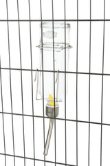 Glas-Wasserflasche mit Metalltrinkröhrchen an einem Gitter befestigt, Markenname "Trixie" sichtbar.