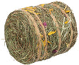 Zylinderförmiges Bündel aus getrocknetem Gras und Blumen mit gelben und violetten Blütenelementen, gebunden mit Bändern.