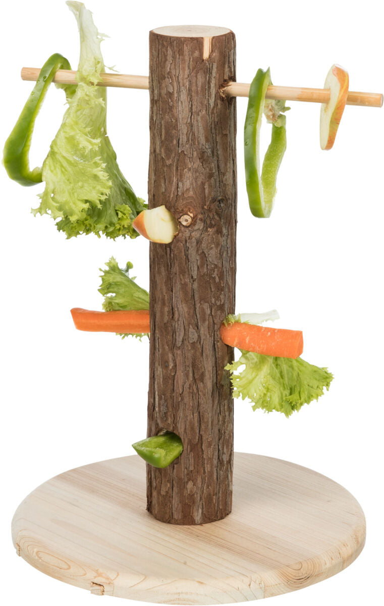 Holzstamm auf rundem Sockel, an dem verschiedene Gemüsesorten wie Salatblätter und Karotten befestigt sind.