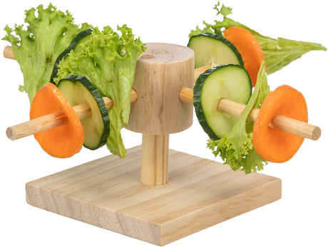 Holzständer mit zwei Spießen, auf denen grüne Salatblätter, Gurkenscheiben und orange Karottenscheiben stecken.