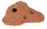 Ein brauner Sandhügel mit mehreren runden Öffnungen, darunter eine größere Öffnung links.