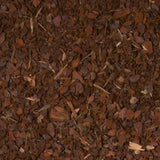 Braune, grobe Holzchips mit vereinzelten kleinen Stöcken und Blättern auf einer Fläche verteilt.
