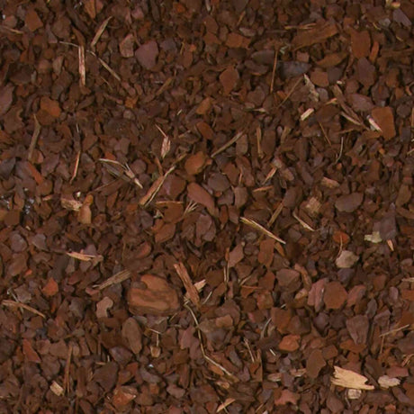 Braune, grobe Holzchips mit vereinzelten kleinen Stöcken und Blättern auf einer Fläche verteilt.
