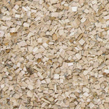 Kleine, helle Holzspäne liegen verstreut und überlappen sich auf einer Fläche.