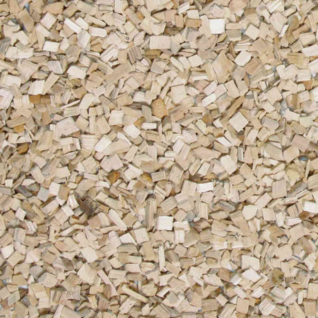 Kleine, helle Holzspäne liegen verstreut und überlappen sich auf einer Fläche.