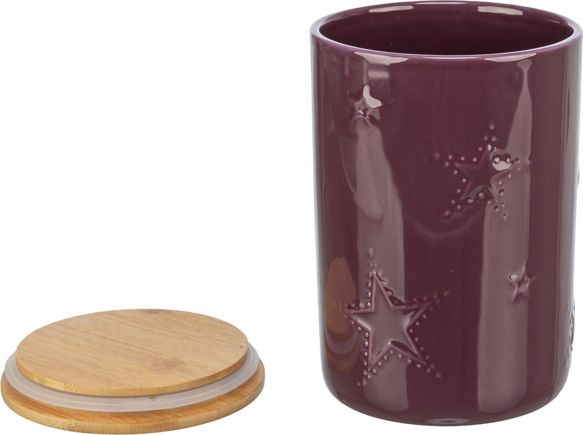 Lila Keramikgefäß mit Sternmotiven und passendem Holzdeckel, der seitlich danebenliegt.