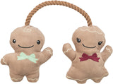 Zwei Plüschfiguren in Puppenform mit Seil verbunden, eine mit grüner Schleife, die andere mit roter Schleife.