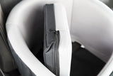 Schwarze und weiße Polsterung mit Reißverschluss an einem Sitz oder Polsterelement.