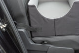 Ein grauer Autositzschutz mit Gurt ist im hinteren Teil eines Fahrzeugs montiert.