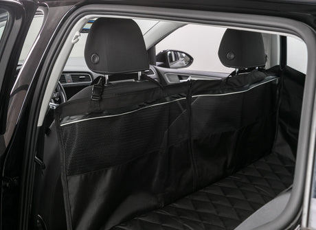 Auto-Innenraum mit schwarzer, gepolsterter Rücksitzabdeckung und Trennschutz hinter den Vordersitzen.