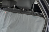 Graue Autoschondecke mit schwarzen Gurten auf den Rücksitzen eines Fahrzeugs befestigt.