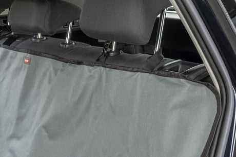Graue Autoschondecke mit schwarzen Gurten auf den Rücksitzen eines Fahrzeugs befestigt.