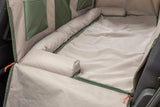 Beige und grüne Hundedeckematte mit seitlichen Polstern in einem Auto.