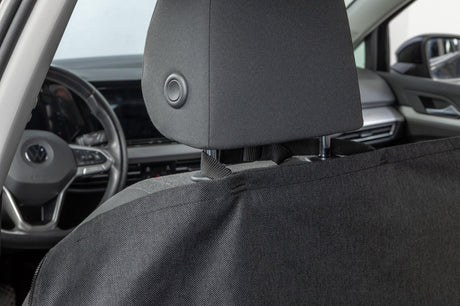 Schwarzer Sitzbezug bedeckt die Rückseite des Vordersitzes in einem Auto.