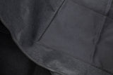 Schwarze Stoffoberfläche mit feiner Textur und sichtbaren Nähten.