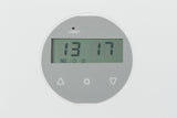 Rundes digitales Display mit grauem Hintergrund, zeigt die Uhrzeit 13:17 und an der Oberseite das Wort "LOBAT".