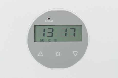 Rundes digitales Display mit grauem Hintergrund, zeigt die Uhrzeit 13:17 und an der Oberseite das Wort "LOBAT".