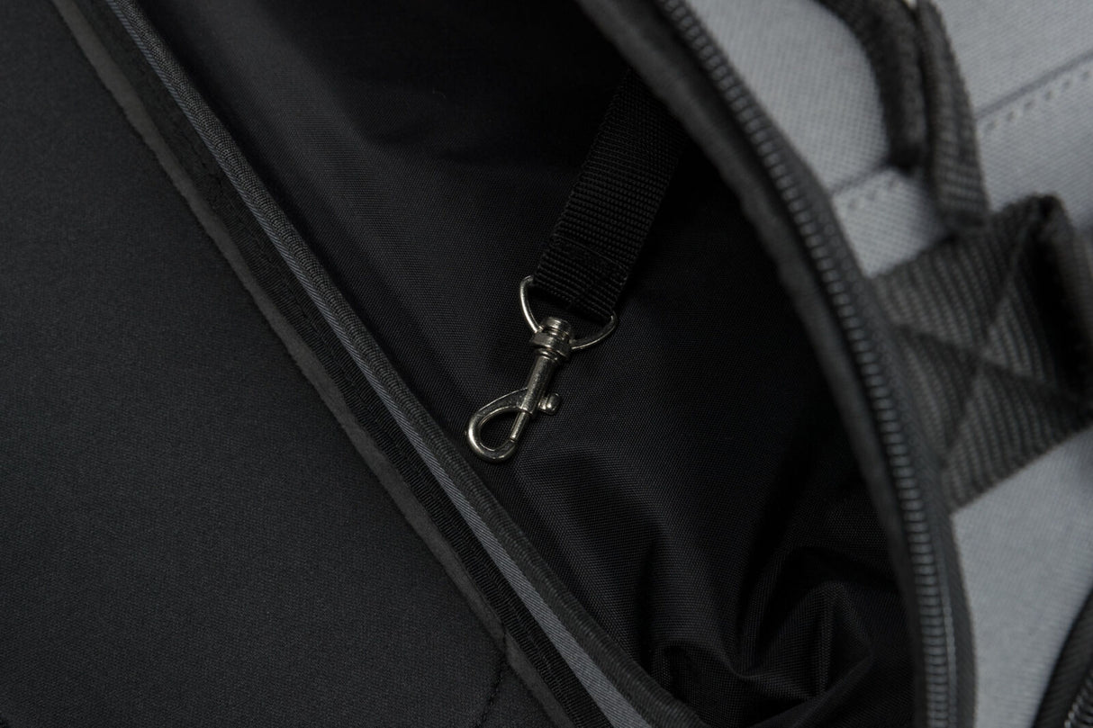 Schwarzer Innenraum einer Tasche oder eines Rucksacks mit einer Metallkarabinerhaken befestigt an einem Gurtband.