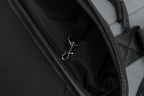 Schwarzer Innenraum einer Tasche oder eines Rucksacks mit einer Metallkarabinerhaken befestigt an einem Gurtband.