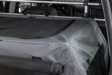 Transportbox mit grauem Stoff und schwarzen Netzeinsätzen befindet sich im Kofferraum eines Autos.