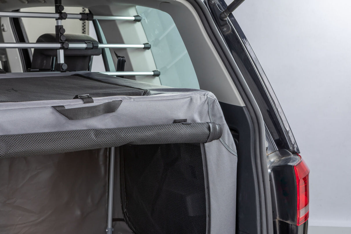 Graue Transportbox im geöffneten Kofferraum eines Autos.