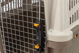 Nahaufnahme eines verschlossenen Gitters mit Plastikrahmen in Beige und schwarzem Verschluss mit gelben Hebeln.
