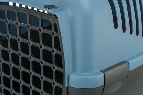 Nahaufnahme einer blauen Transportbox mit schwarzem Gitter und grauen Befestigungselementen.