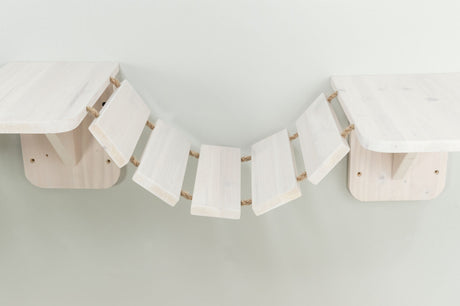 Helle Holzplattformen mit gebogener Hängebrücke aus Holzplanken, verbunden durch Seile; an der Wand montiert.
