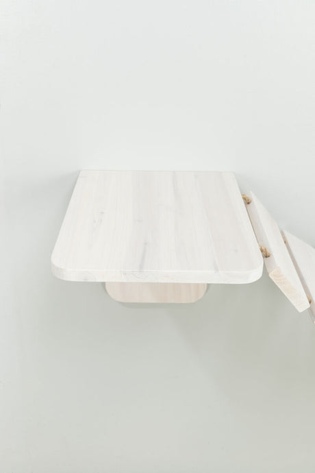 Eine helle, hölzerne Wandablage mit abgerundeten Ecken ist an einer weißen Wand befestigt.